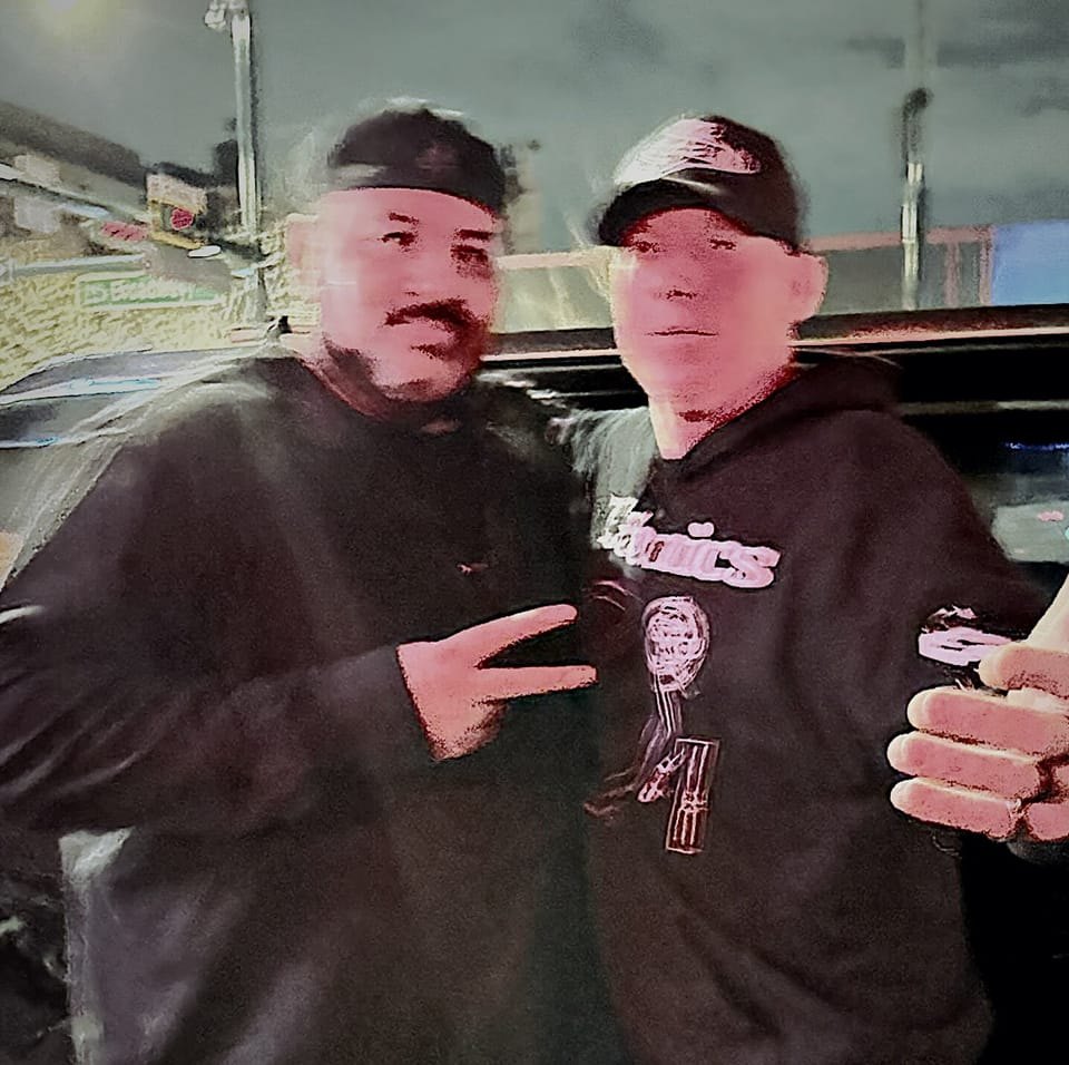DJ Natural Nate® in Technics hoodie with a friend, pink-toned street night selfie